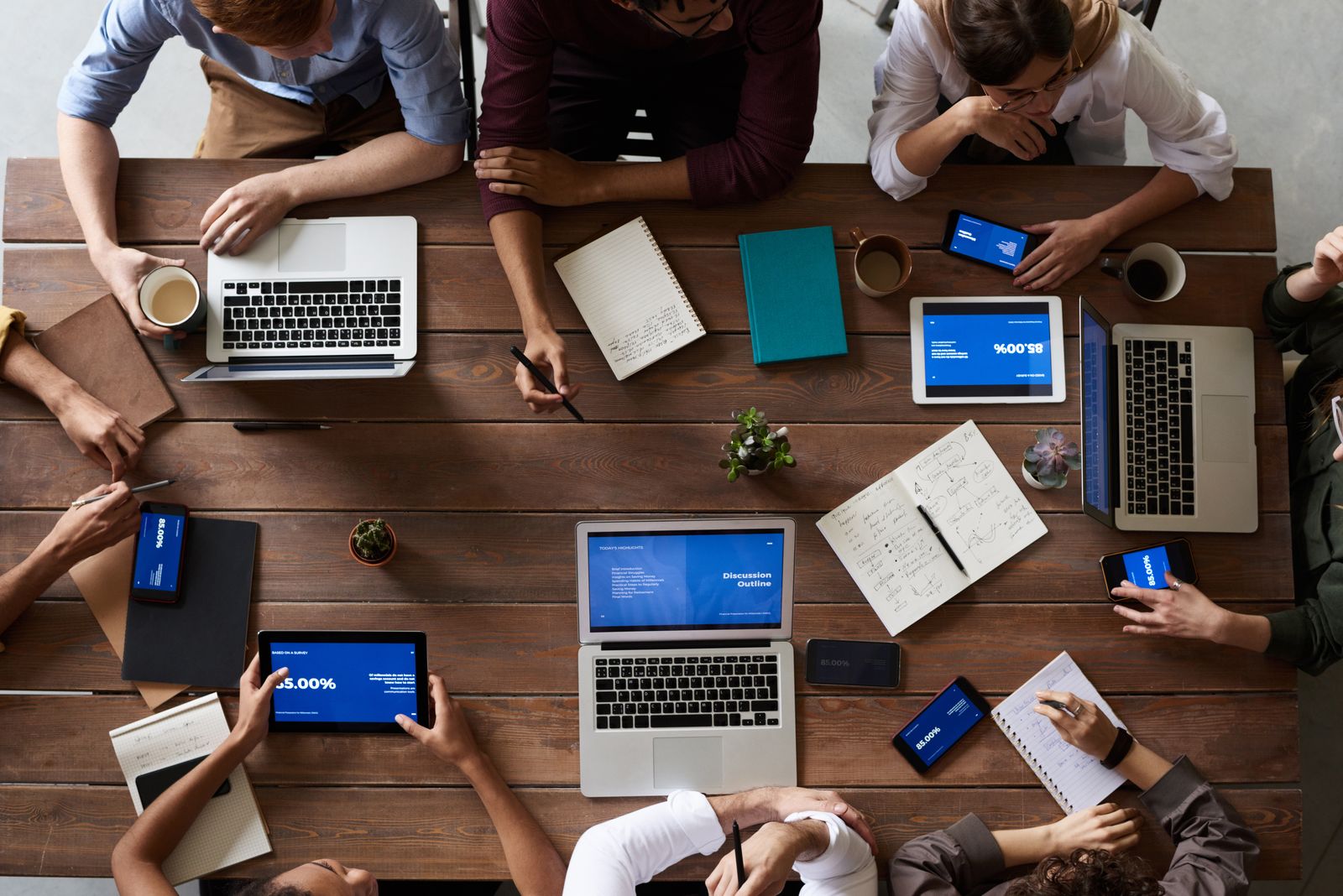 Equipe trabalhando em conjunto com notebooks e dispositivos